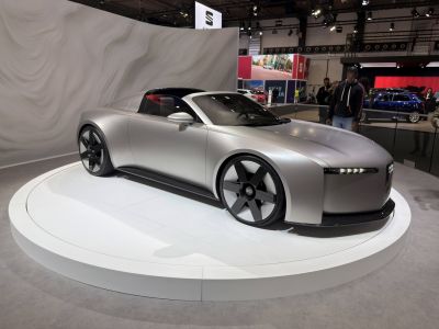 Sleek silver concept electric sports coupe with aerodynamic body and LED headlights.