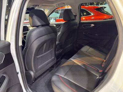 Rear passenger seats with black leather and red stitching