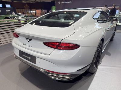 Rear view of luxury coupe with sleek tail lights and quad exhaust.