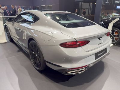 Rear view of luxury coupe with quad exhaust and black wheels
