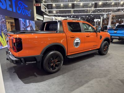 Orange double cab pickup truck with black wheels, side and rear view