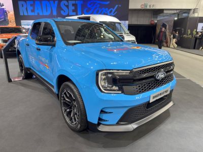 Sporty pickup truck front with black honeycomb grille and dynamic headlights