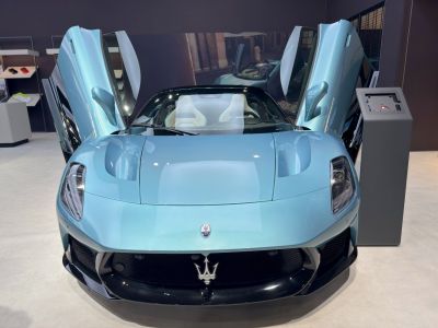 Front view of a luxury sports car with butterfly doors open.