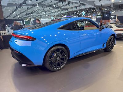 Sleek blue coupe showcasing rear design and black alloy wheels