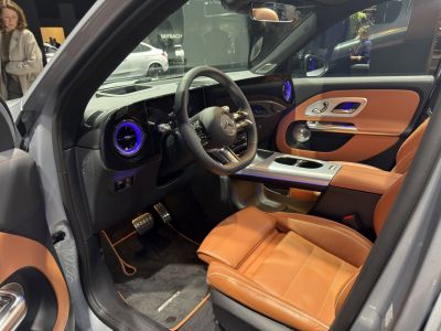 Luxury car interior with brown leather seats and blue ambient lighting