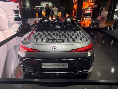 Rear view of a sleek twin-seat sports vehicle with distinctive tail lights and quad exhausts.