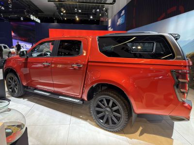 Red double cab pickup with black alloy wheels and canopy