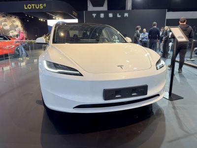 Front view of a white electric sedan with sleek LED headlights.