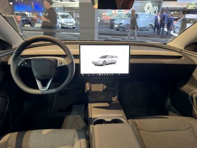 Minimalist dashboard with large central touchscreen and steering wheel