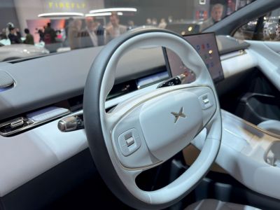 Electric steering wheel with dual controls and digital dashboard display.