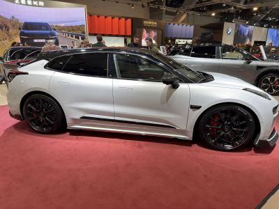 Side view of sleek car with black alloy wheels and red brake calipers