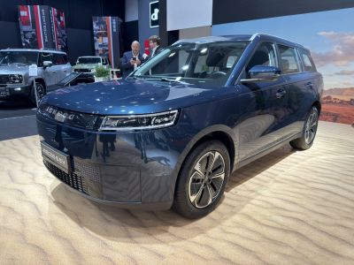 Front and side view of a blue electric SUV with modern headlights and aerodynamic wheels.