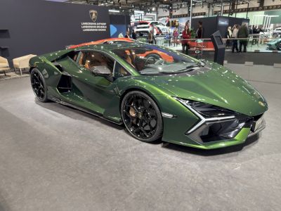 Green Lamborghini with angular headlights and black multi-spoke wheels