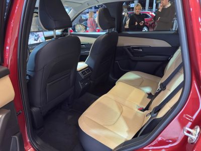 Spacious rear seat area with beige leather upholstery and rear ventilation controls.