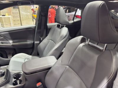 Premium front leather seats with padded armrest in modern EV interior