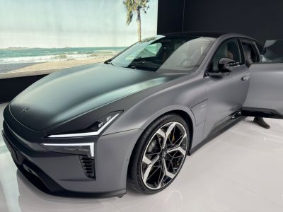 Sleek electric sedan front with futuristic LED headlights and alloy wheels.