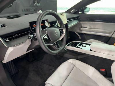 Modern dashboard and steering wheel with digital displays and premium seats.