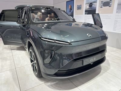 Front view of electric SUV with sleek headlights and open driver door