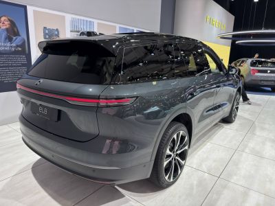 Sleek rear three-quarter view with LED tail light strip and black roof