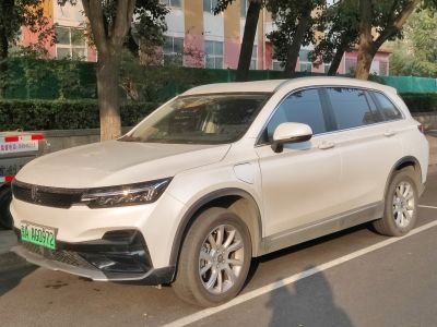 Front side view of an electric SUV with sleek headlights and charging port