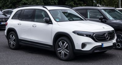 White electric SUV with sleek grille and modern alloy wheels.