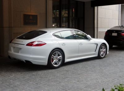 White luxury sports sedan rear and side view with alloy wheels