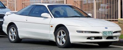 White coupe with aerodynamic design and alloy wheels.