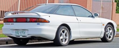 Rear and side view of a white coupe with spoiler and iconic tail lights.