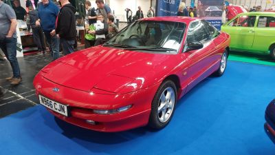 Red sports coupe with pop-up headlights and sleek aerodynamic design