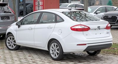 White sedan showing rear and side view with alloy wheels