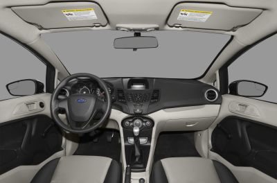 Car interior with dashboard, steering wheel, and manual transmission