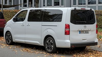 Rear side view of white van with tinted windows and sliding door