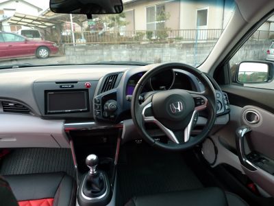 Manual gear shift and steering wheel controls in compact car interior