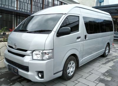 Silver high-roof passenger van with tinted windows, front side view