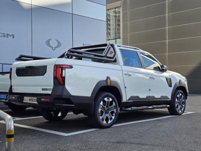 Pickup truck with long deck and a black tubular frame over cargo bed.