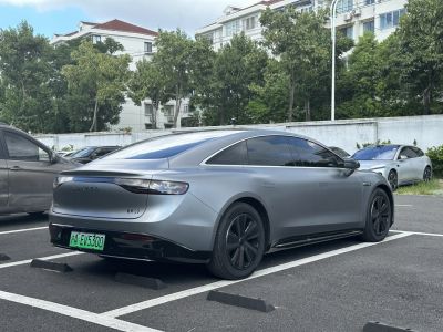 Rear and side view of a sleek electric sedan with aerodynamic lighting and tinted windows