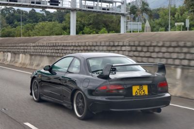 Rear view of a black coupe with large rear spoiler