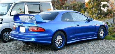 Blue coupe with large rear spoiler and custom alloy wheels