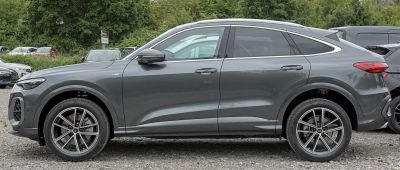 Side view of a sleek modern SUV coupe with sporty 5-spoke alloy wheels.