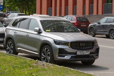 Modern SUV front grille and alloy wheels in silver parked on street