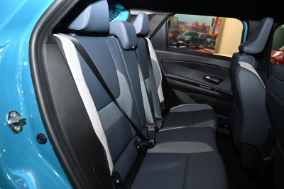 Rear seat with blue upholstery and integrated safety belts.