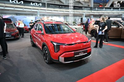 Modern LED headlights and aerodynamic compact SUV design in a showroom.