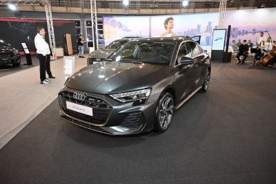 Front view of a grey sedan with distinct grille and LED headlights