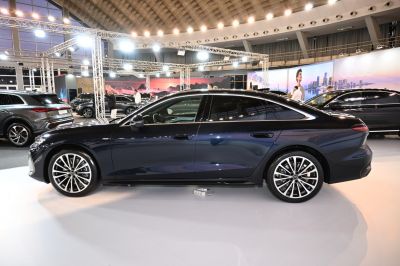 Side profile of a sleek sedan with detailed alloy wheels and smooth body lines.