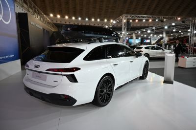 White luxury station wagon with roof box and black wheels