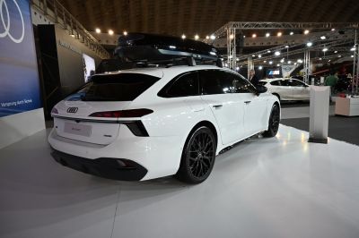 White station wagon with large black roof box and sport black wheels