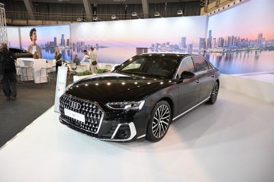 Luxury sedan with distinctive grille and alloy wheels in front angled view.