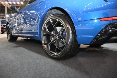 Close-up of alloy wheel and rear side of a blue SUV