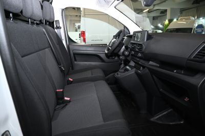 Van interior with front bench seats and dashboard featuring manual transmission