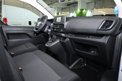 Spacious and functional van interior with modern dashboard and manual transmission.